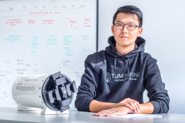 Haokun Zheng, einer der Teamleader des TUM Boring – Innovation in Tunneling e. V. mit einem Prototypen der Tunnelbohrmaschine. © Foto: Andreas Heddergott / TUM 