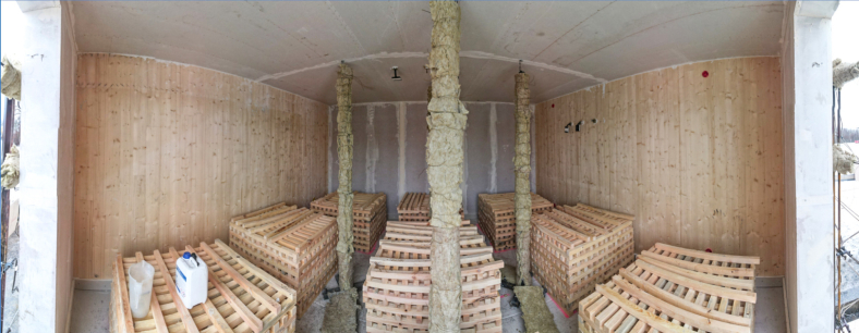 Diese 180-Grad-Aufnahme einer Drohne zeigt den Versuchsaufbau für den dritten Realbrandversuch. Zwei der gegenüberliegenden Wände wurden ohne Brandschutzverkleidung ausgeführt. Bild: TUM/Christoph Kurzer