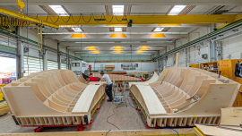 Lösung komplexer Anforderungen: Um die komplexe Formgebung mit Brettstrukturbelegung zu realisieren, wurden die dreidimensional gekrümmten Sonderschalungselemente von PERI maßgenau vormontiert und einsatzfertig auf die Baustelle geliefert. 