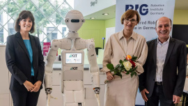 Prof. Angela Schoellig von der Technischen Universität München (links), Bundesforschungsministerin Bettina Stark-Watzinger (Mitte) mit Prof. Tamim Asfour vom Karlsruher Institut für Technologie bei der Vorstellung des RIG in Berlin. Mit dabei: Roboter ARMAR-7 aus dem KIT. Foto: Hans-Joachim Rickel / BMBF