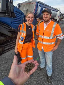 Anna Stenglein, Masterstudierende der OTH Regensburg, und Andreas Hauser, Projektleiter der Autobahn GmbH, mit Acrylfaserpellet. Foto: Andreas Appelt/OTH Regensburg 